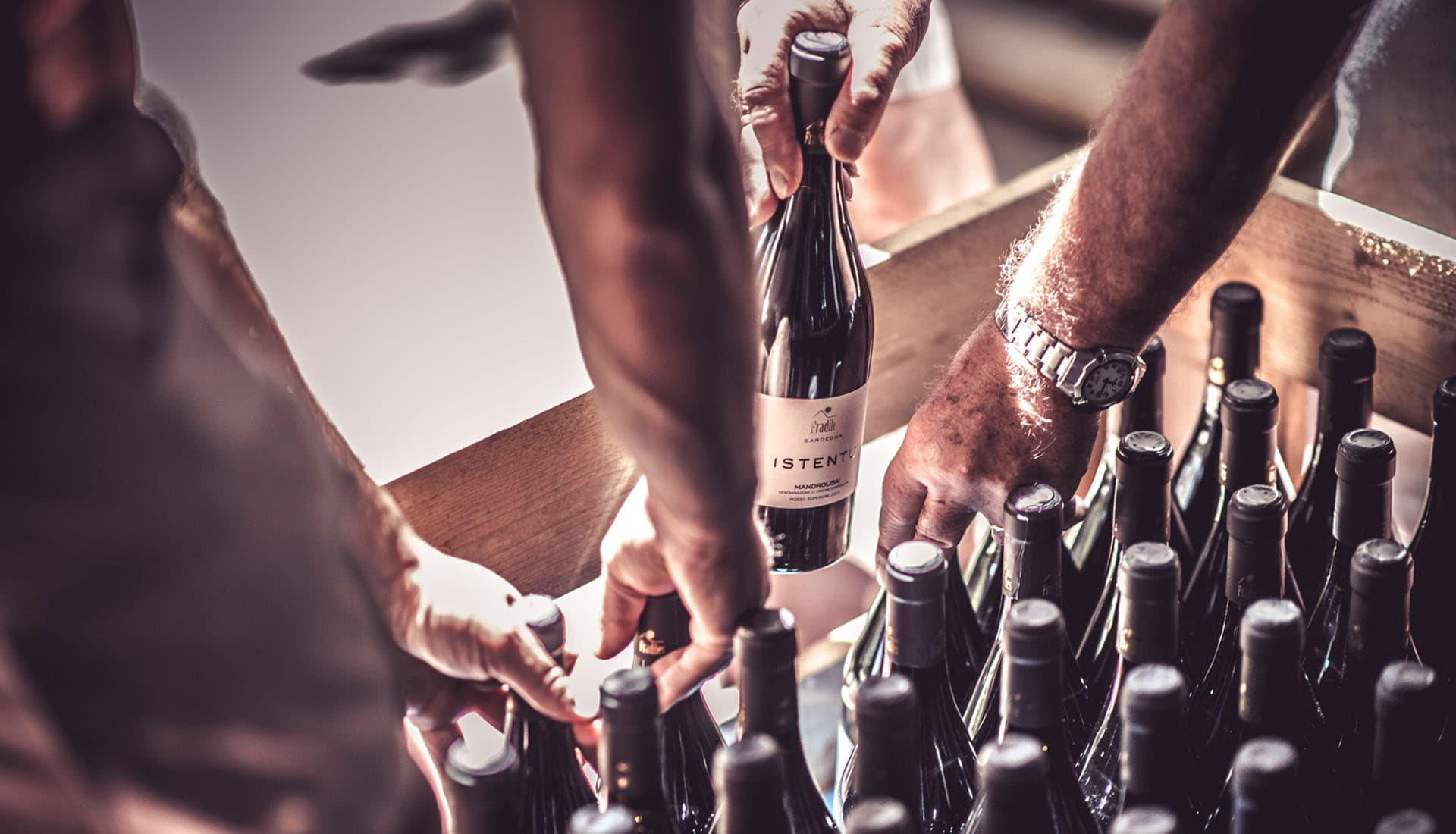 People reaching for a case of Fradiles wine